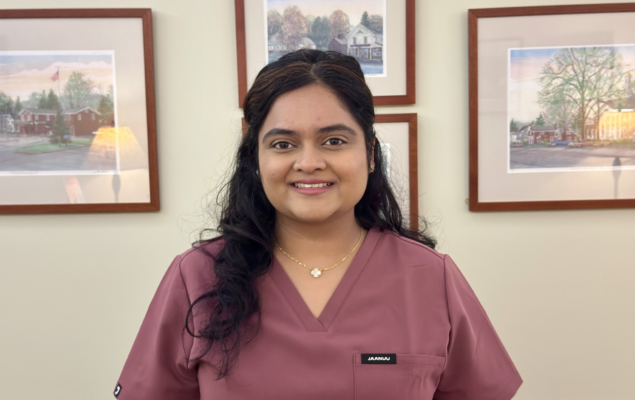 Dr. Krupa Patel smiling in mauve scrubs in a dental office setting